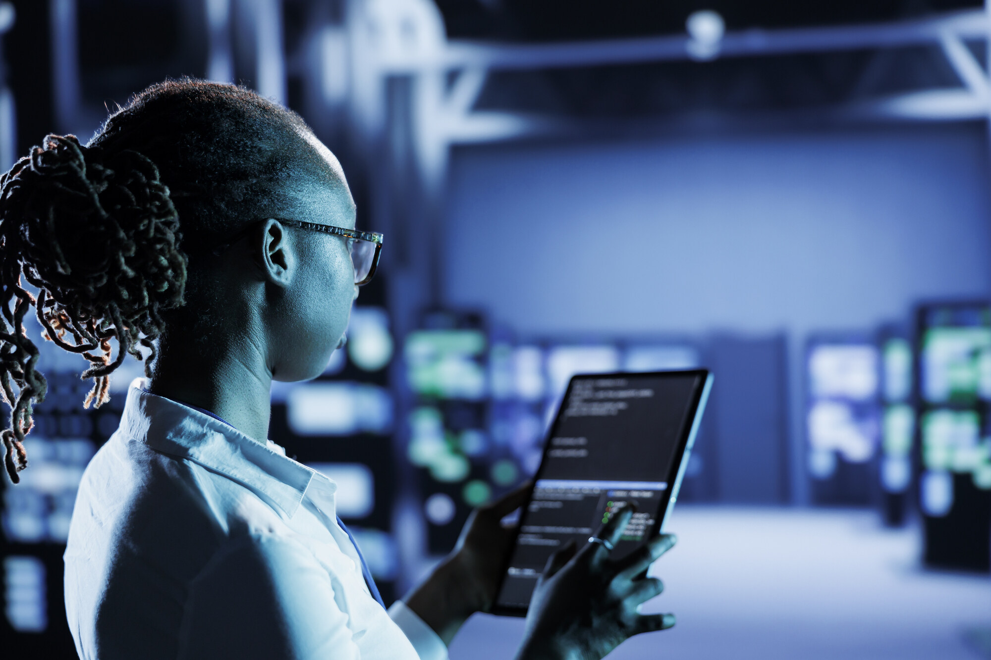 System administrator monitoring firewall protection in a server room